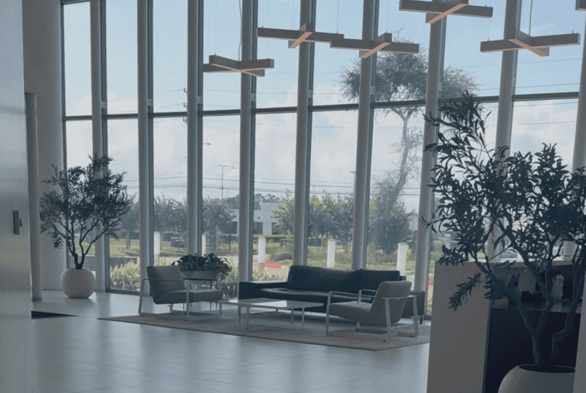 Modern salon waiting area with large windows and stylish furniture.