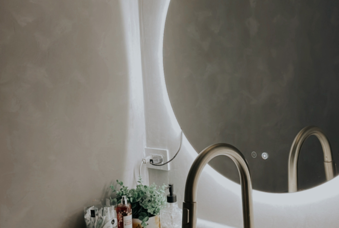 Modern salon wash basin with stylish mirror and lighting fixtures.