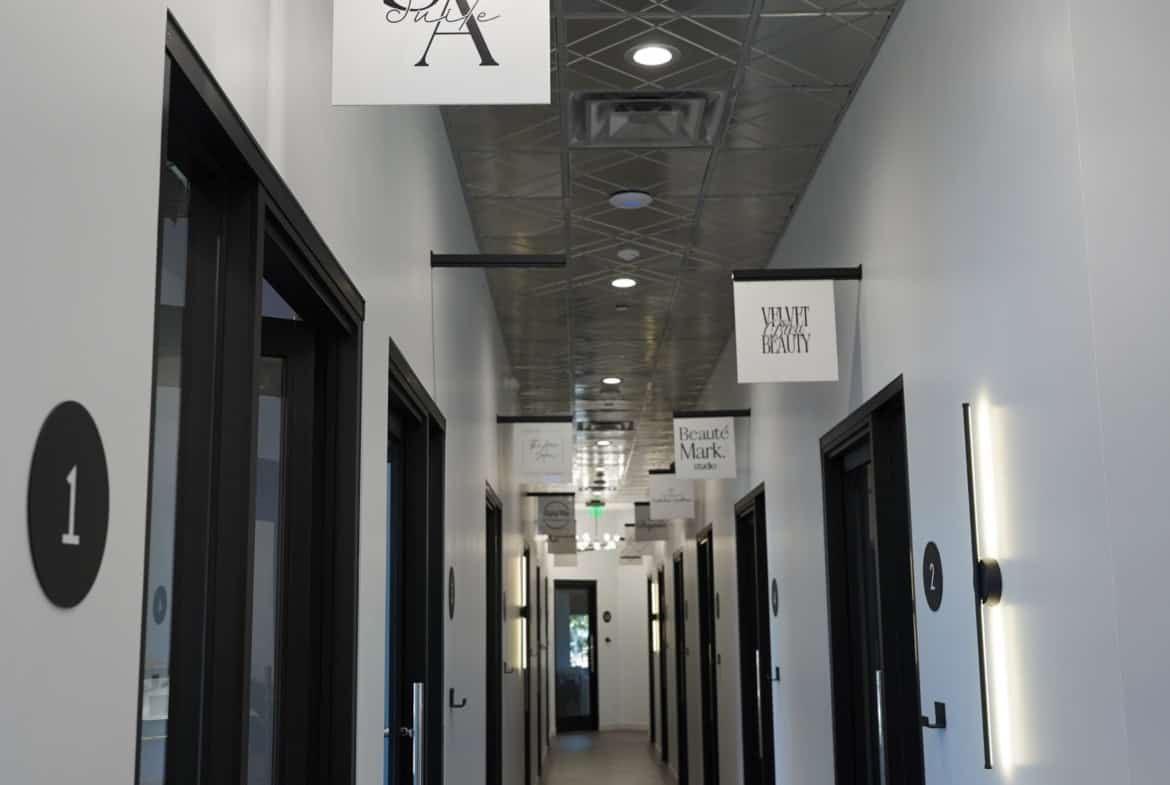 Elegant hallway with private salon suites and stylish lighting fixtures.