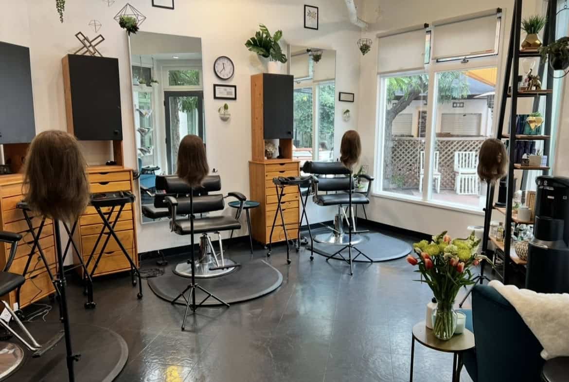 Hair salon styling stations with mannequins and professional tools.