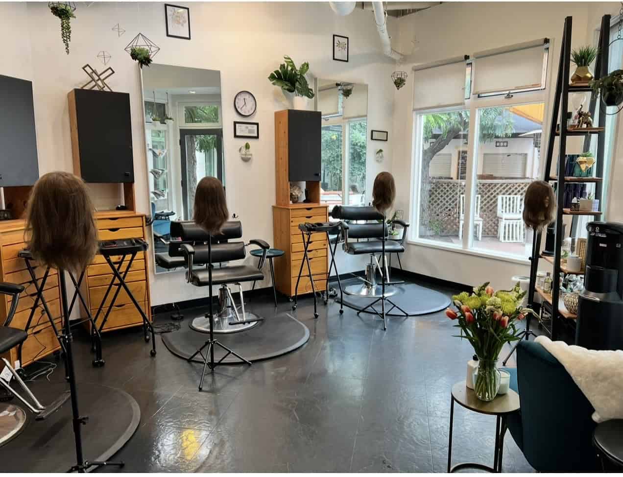 Hair salon styling stations with mannequins and professional tools.