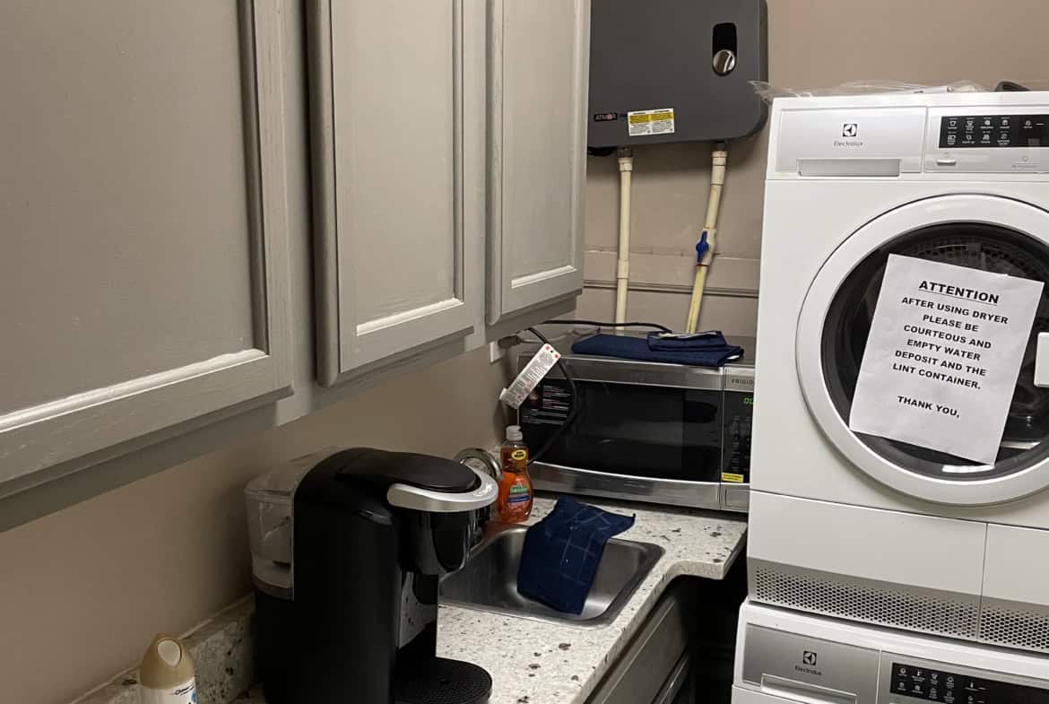 Laundry and utility room with washer, dryer, and storage cabinets.