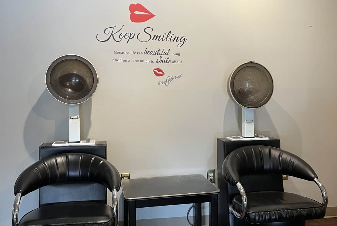 Wall art with a woman's face and motivational quote in a salon.