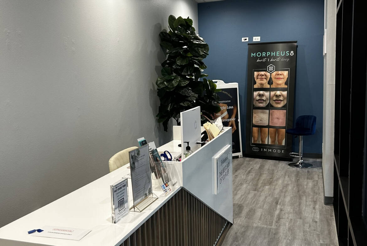 Reception desk at Salon Renter with modern decor and branding display.