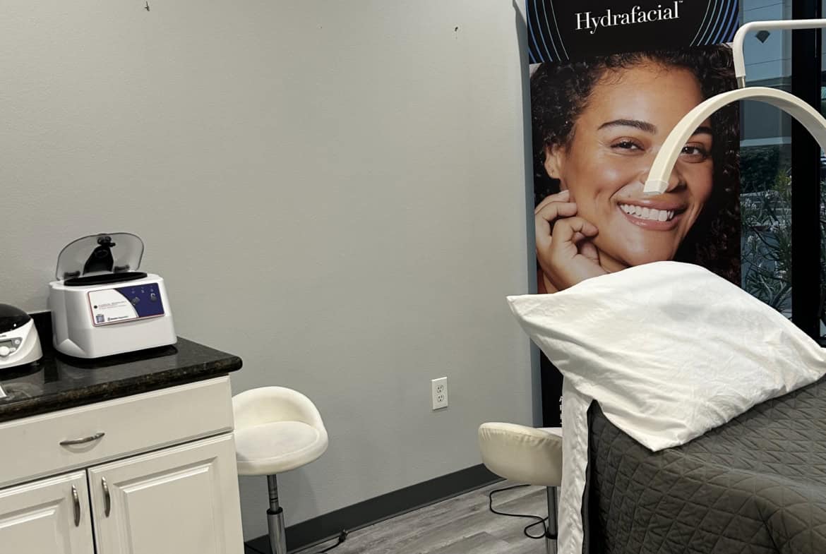 Hydrafacial treatment room with skincare equipment and treatment bed.