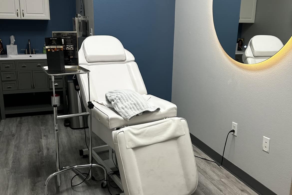 Modern salon treatment chair with medical equipment in a clean, professional beauty clinic.
