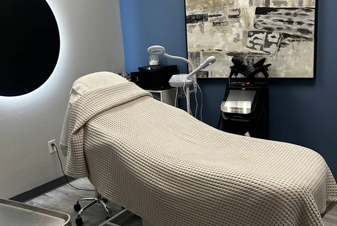 Relaxing salon treatment room with massage bed, medical tools, and contemporary decor.