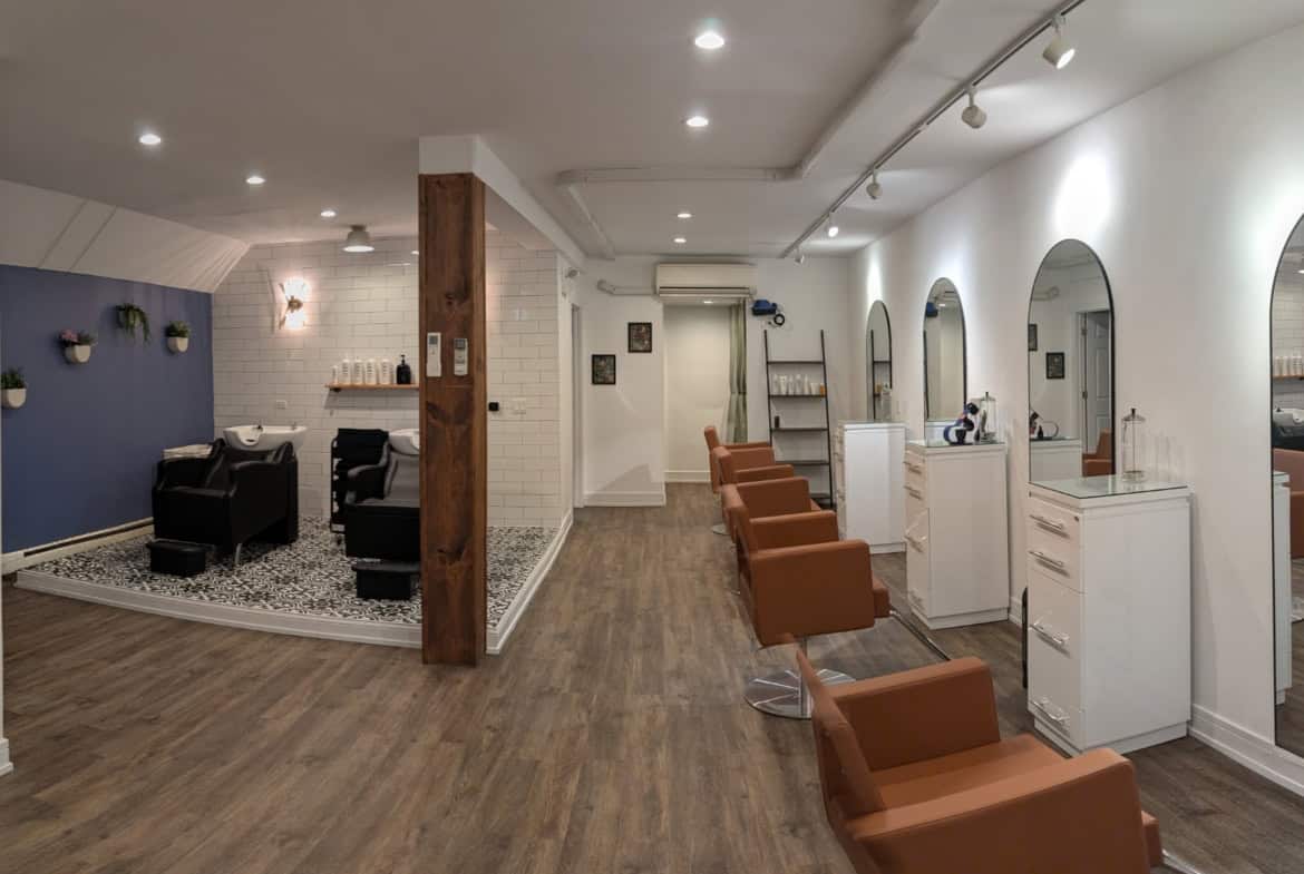 Salon Renter interior with styling stations, mirrors, and salon chairs for hair services. Bright, cl.