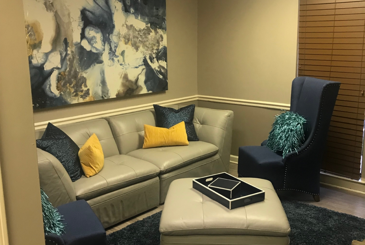 Cozy salon waiting area with plush chairs, decorative pillows, and contemporary artwork.