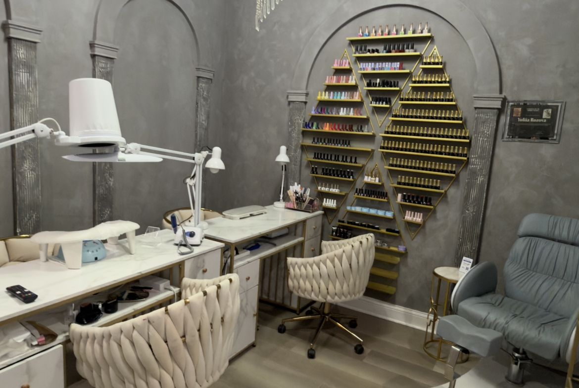 Modern salon nail station with organized nail polish display and comfortable seating.
