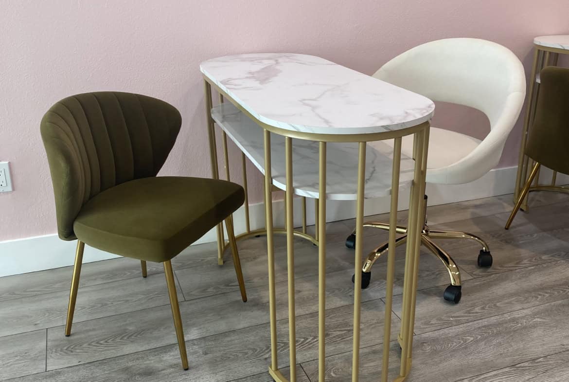Stylish salon waiting area with comfortable chairs and a marble-topped table for clients.