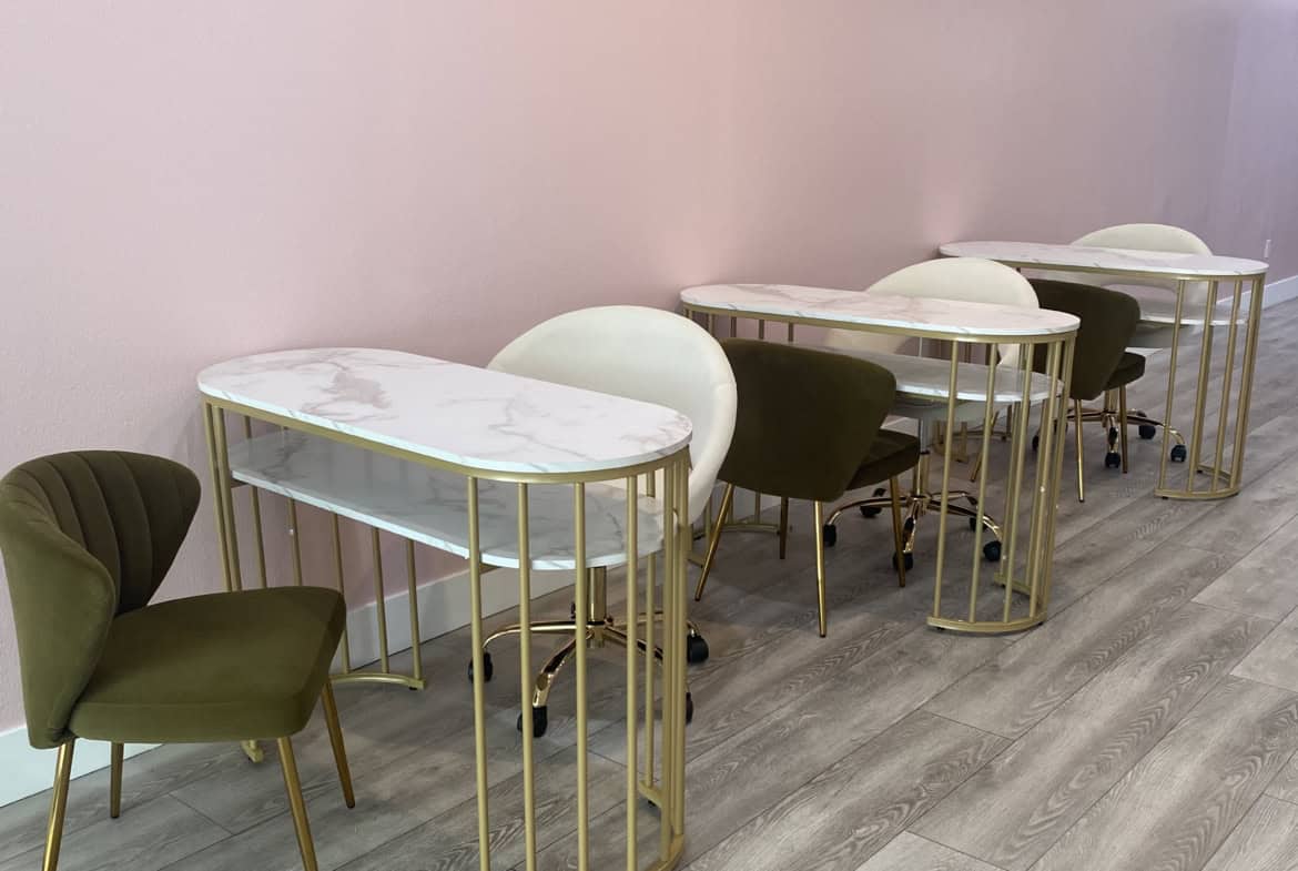 Modern salon waiting area with pastel pink wall and stylish seating.