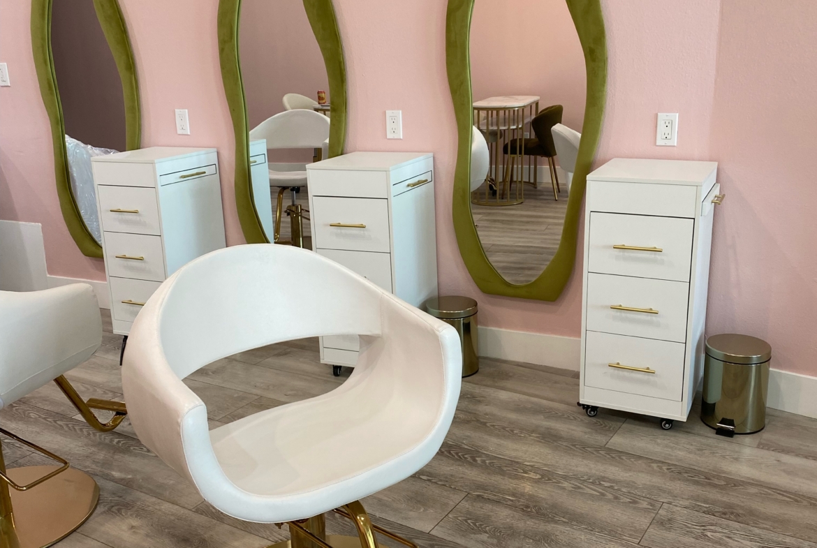 Stylish salon station with three mirrors, white furniture, and a comfortable chair for hair styling.