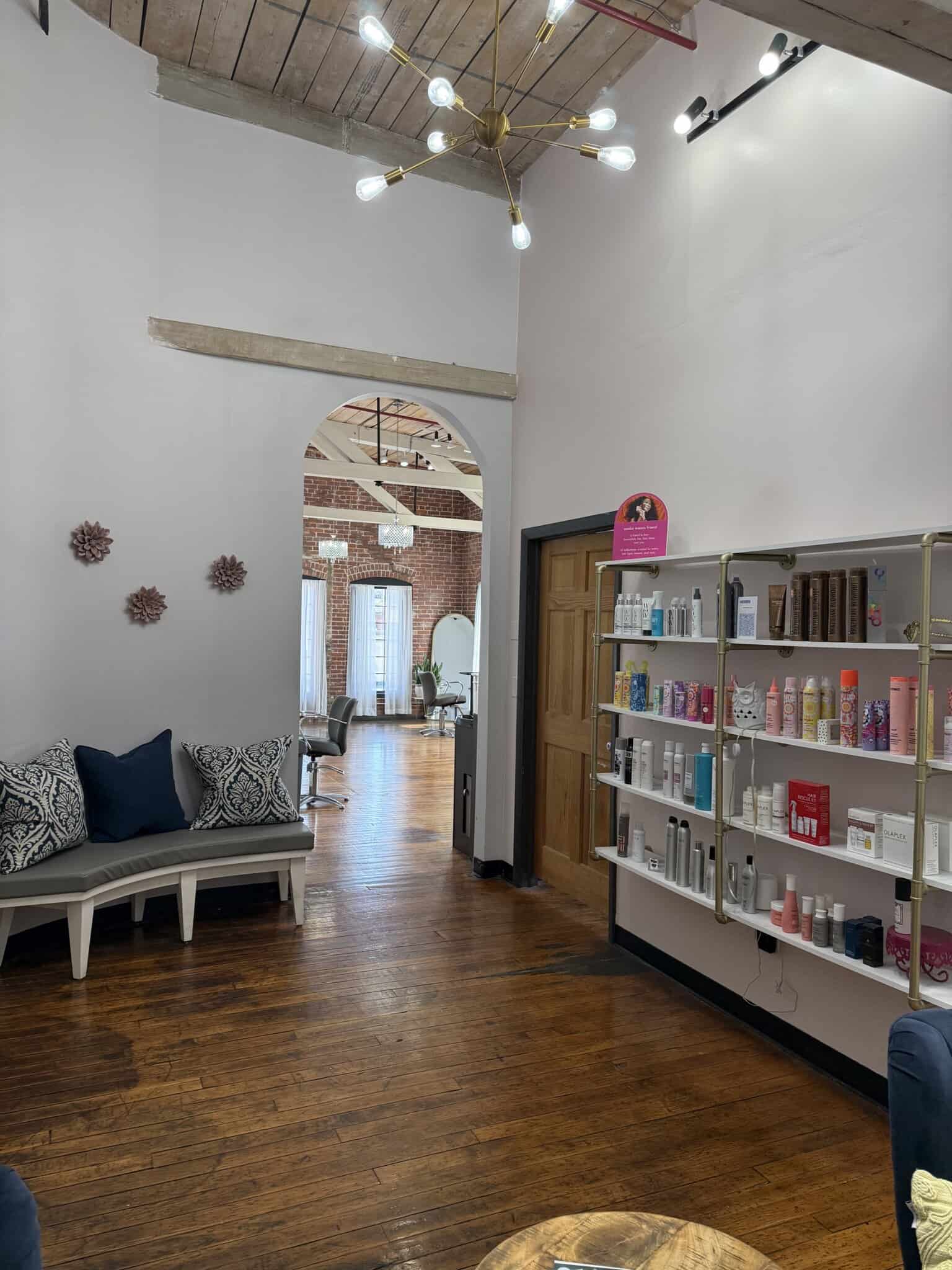 Modern salon interior with product shelves and seating area.