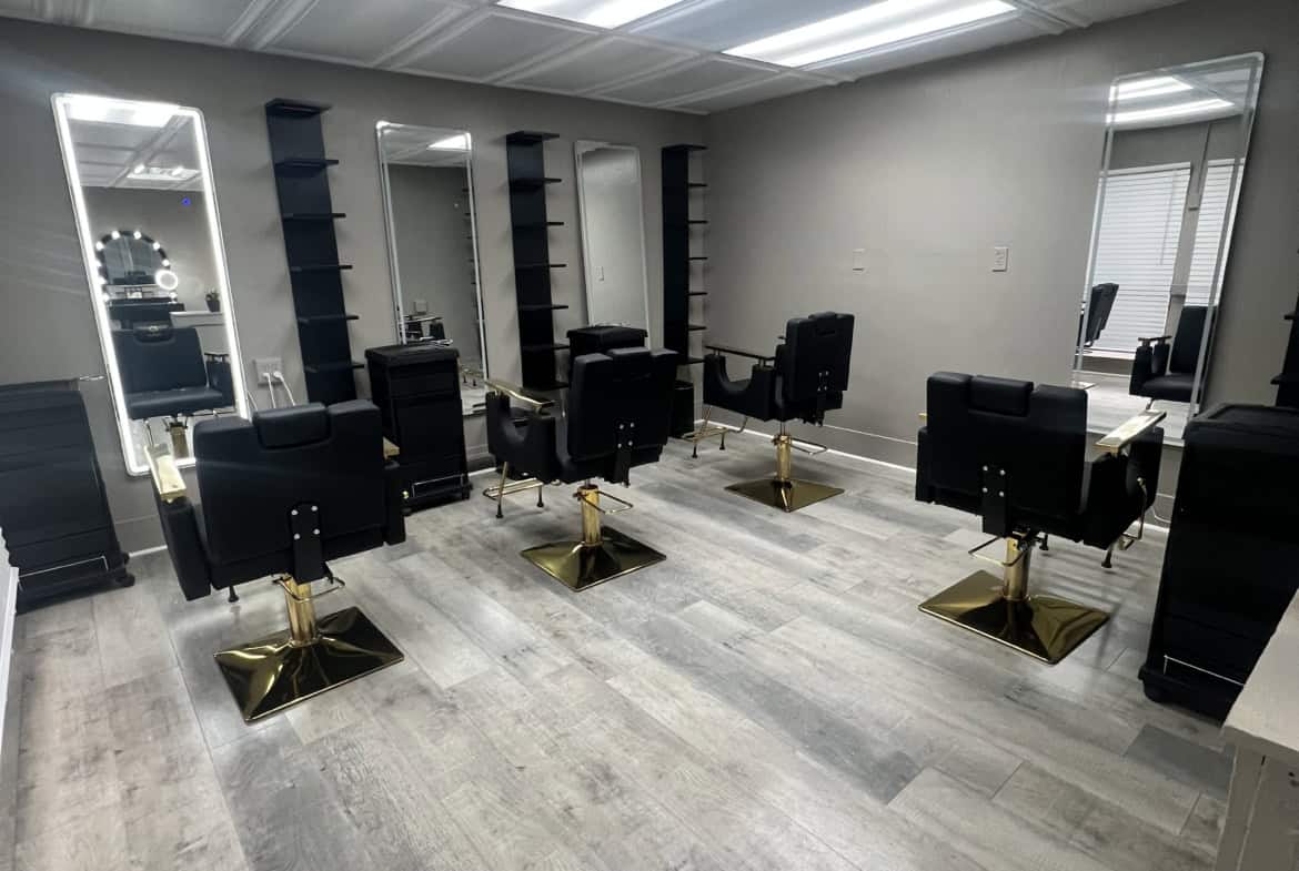 Salon Renter - Modern hair styling stations with black chairs and mirrors in a bright, clean salon s.