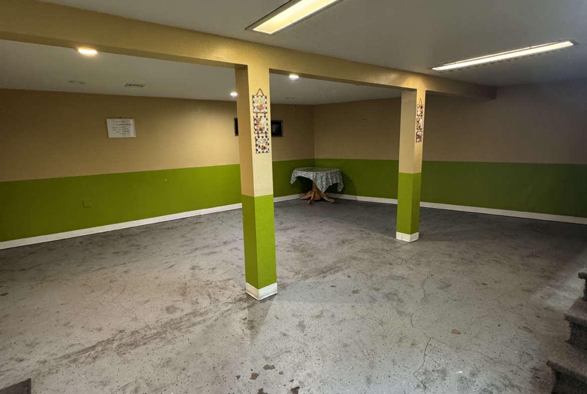 Bright, open salon rental space with ample lighting and support columns, ideal for beauty profession.