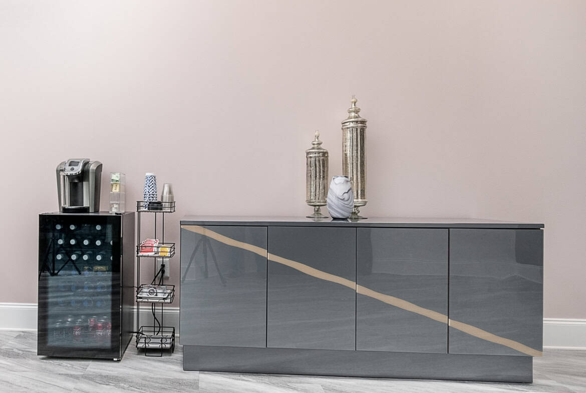 Modern salon furniture and decor with sleek gray cabinet and decorative accents.