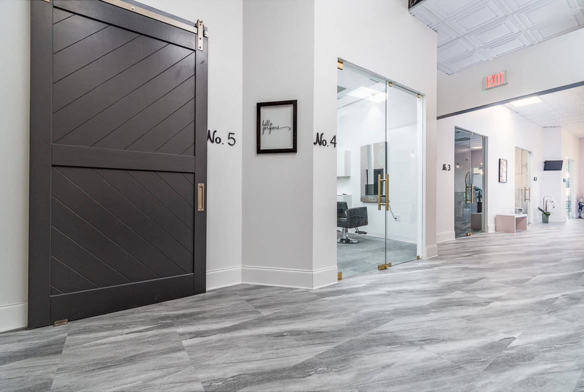 Elegant salon rental suites with glass doors and contemporary interior design.