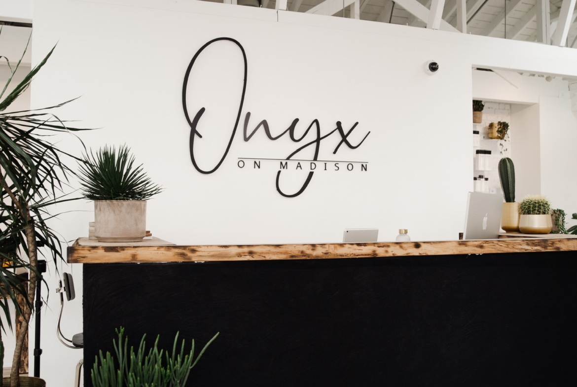 Modern salon reception with Onyx on Madison sign and stylish decor.
