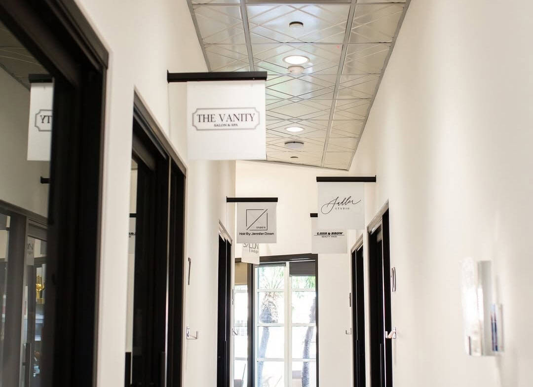 Bright hallway of premium salon suites in Hurst, TX with stylish signage and modern decor.