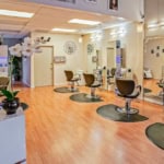 Modern salon interior with styling stations, chairs, and shelves of hair products for hair styling a.