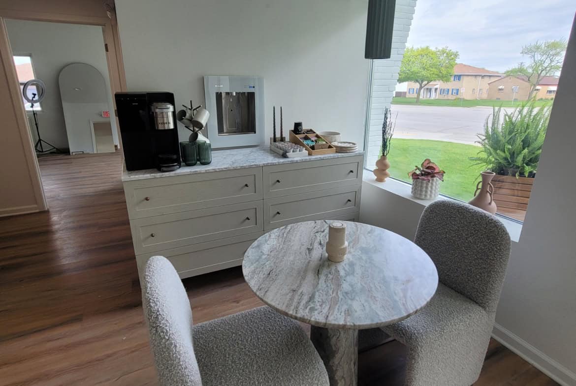 Comfortable salon lounge with round table and large window view.