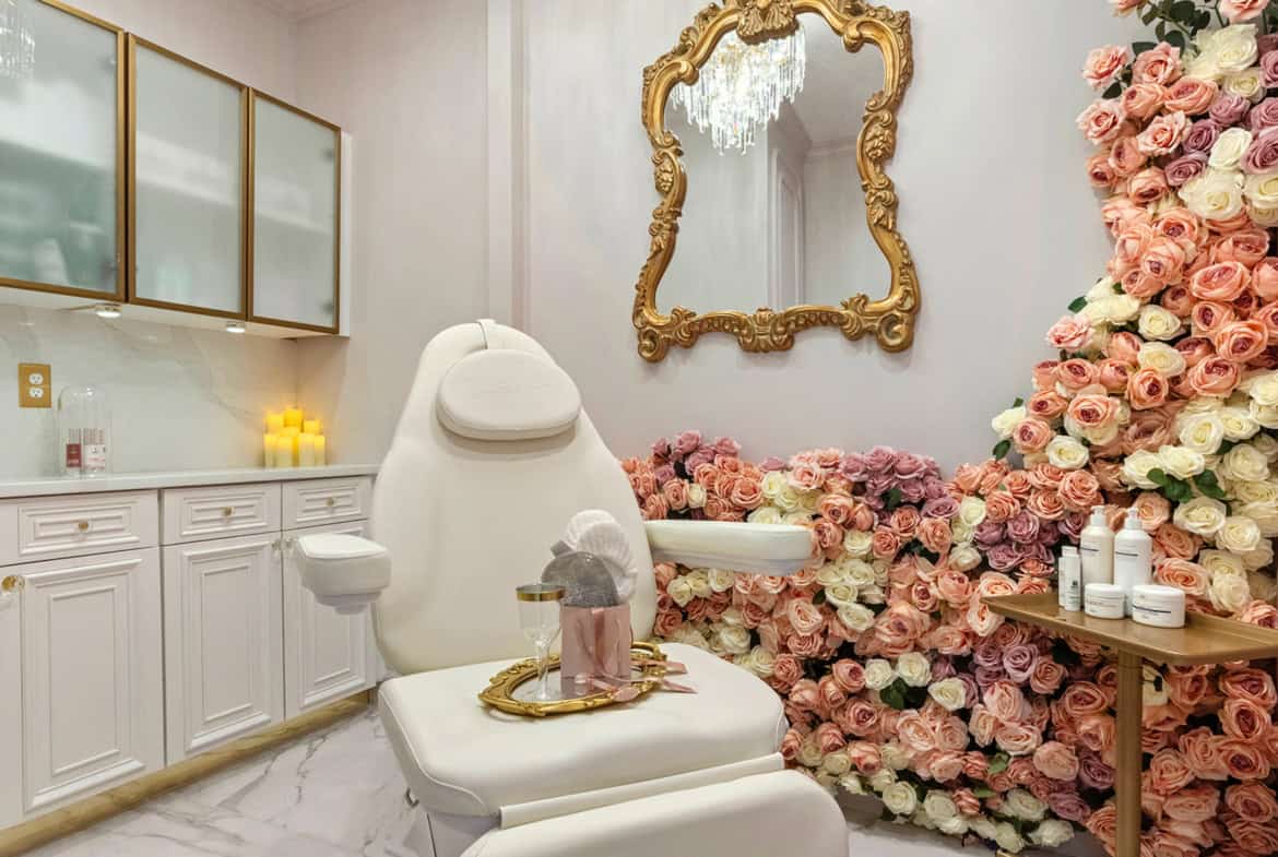 Elegant salon treatment room featuring a luxurious chair, floral arrangements, and ornate mirror for.