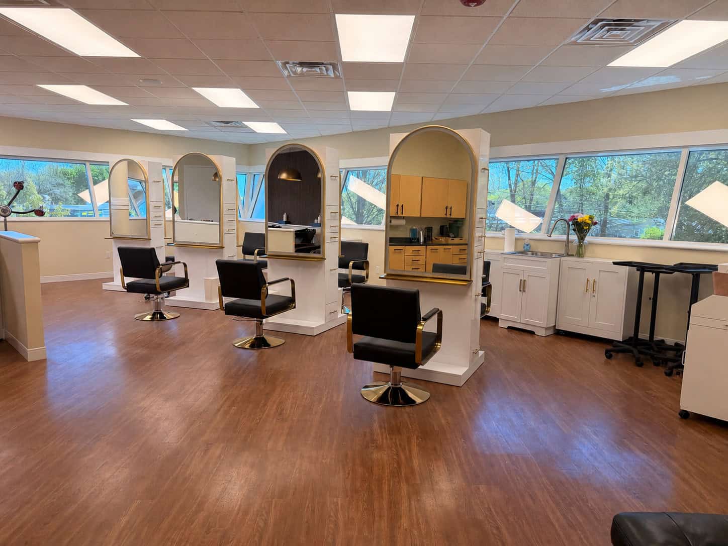 Stylish salon stations with mirrors and chairs for hair styling and beauty services.