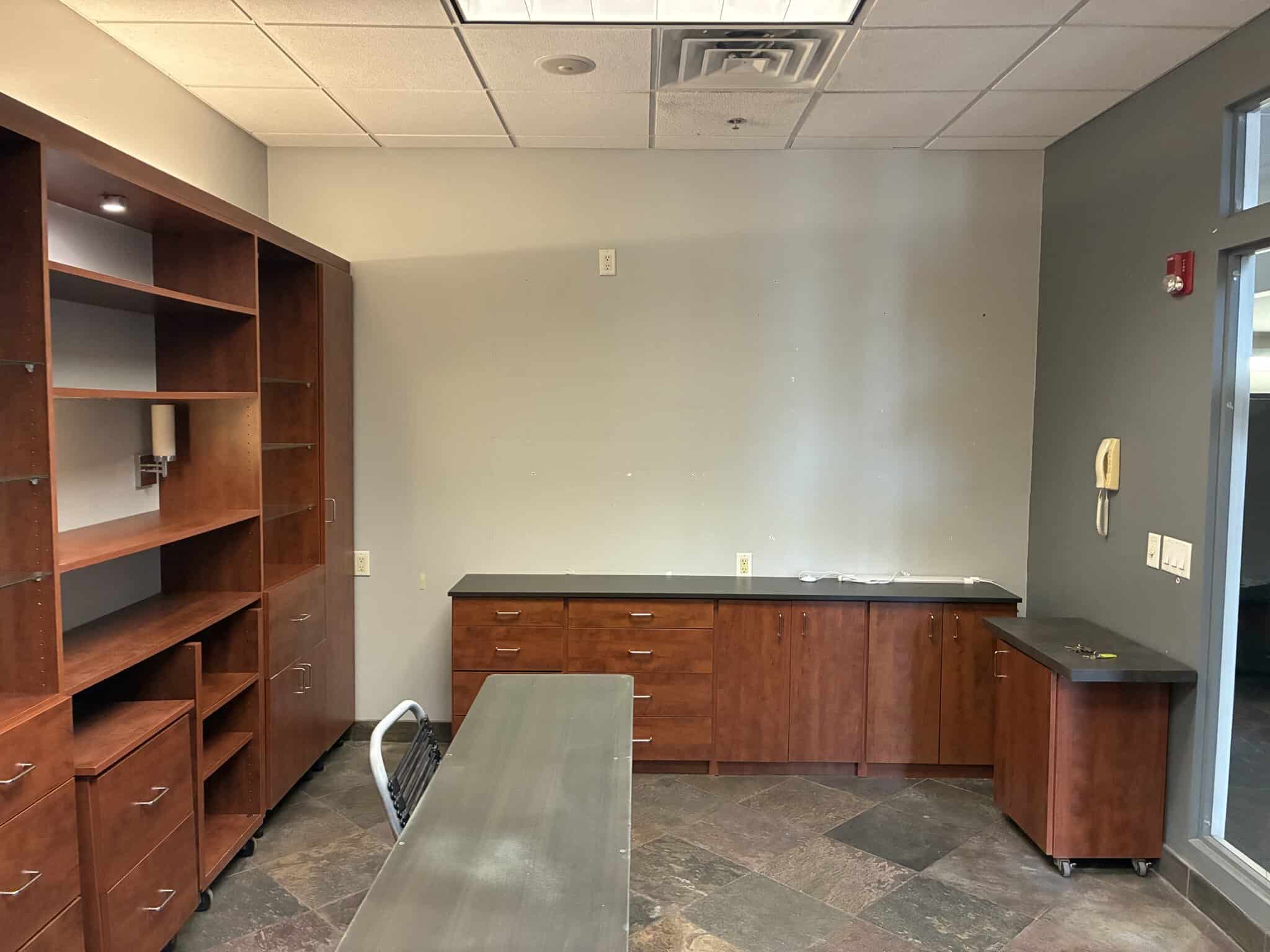 Modern salon storage and workspace with wooden cabinets and shelves.