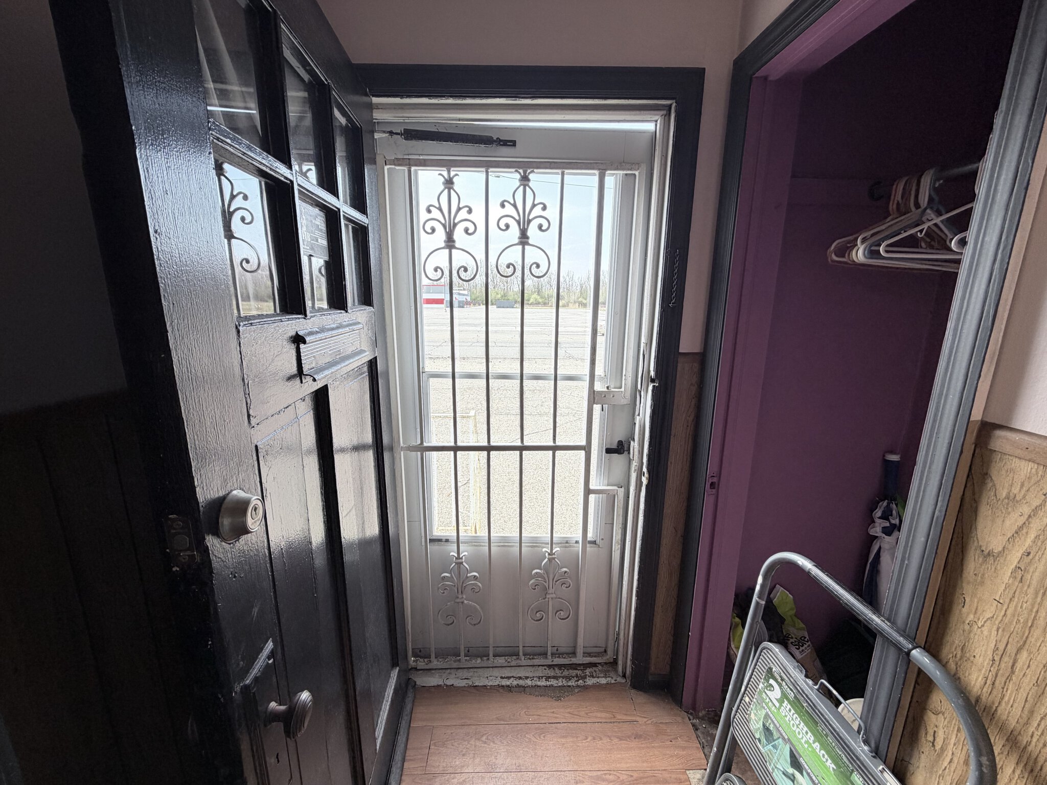 Secure entrance door with decorative iron grille for salon rentals.