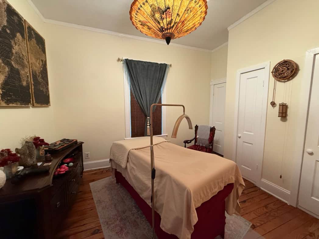Cozy massage room with massage table, soft lighting, and calming decor at Salon Renter.
