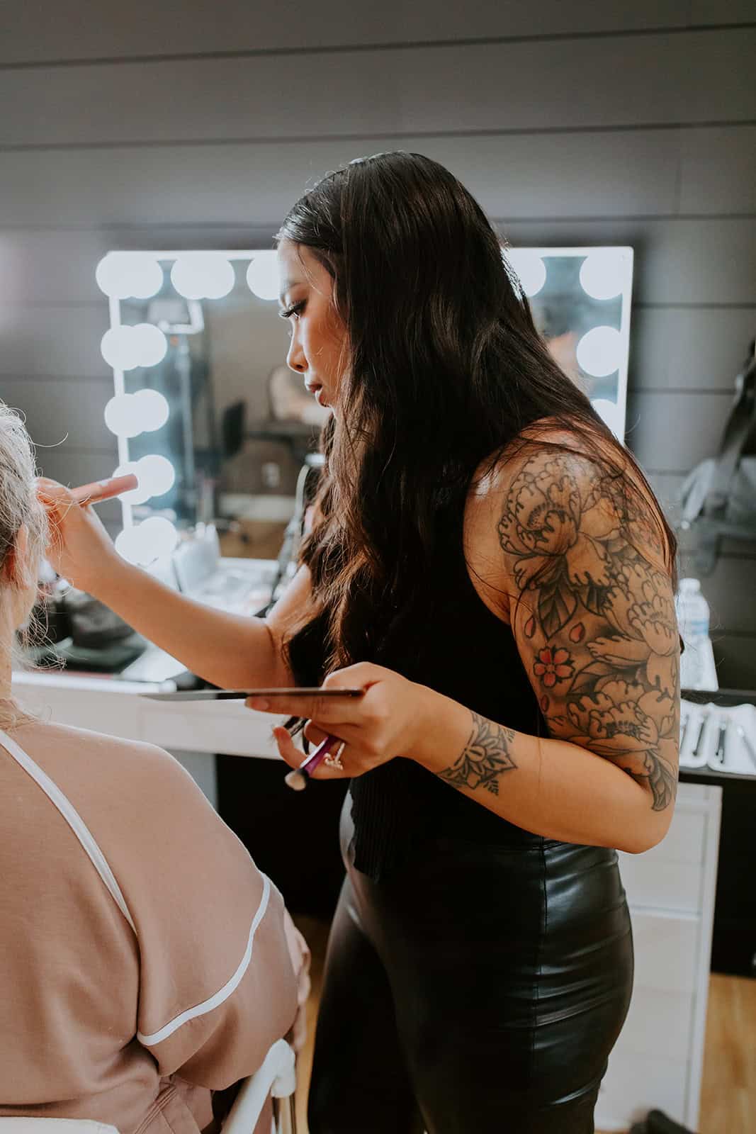 Professional makeup artist applying makeup to a client in a salon setting.