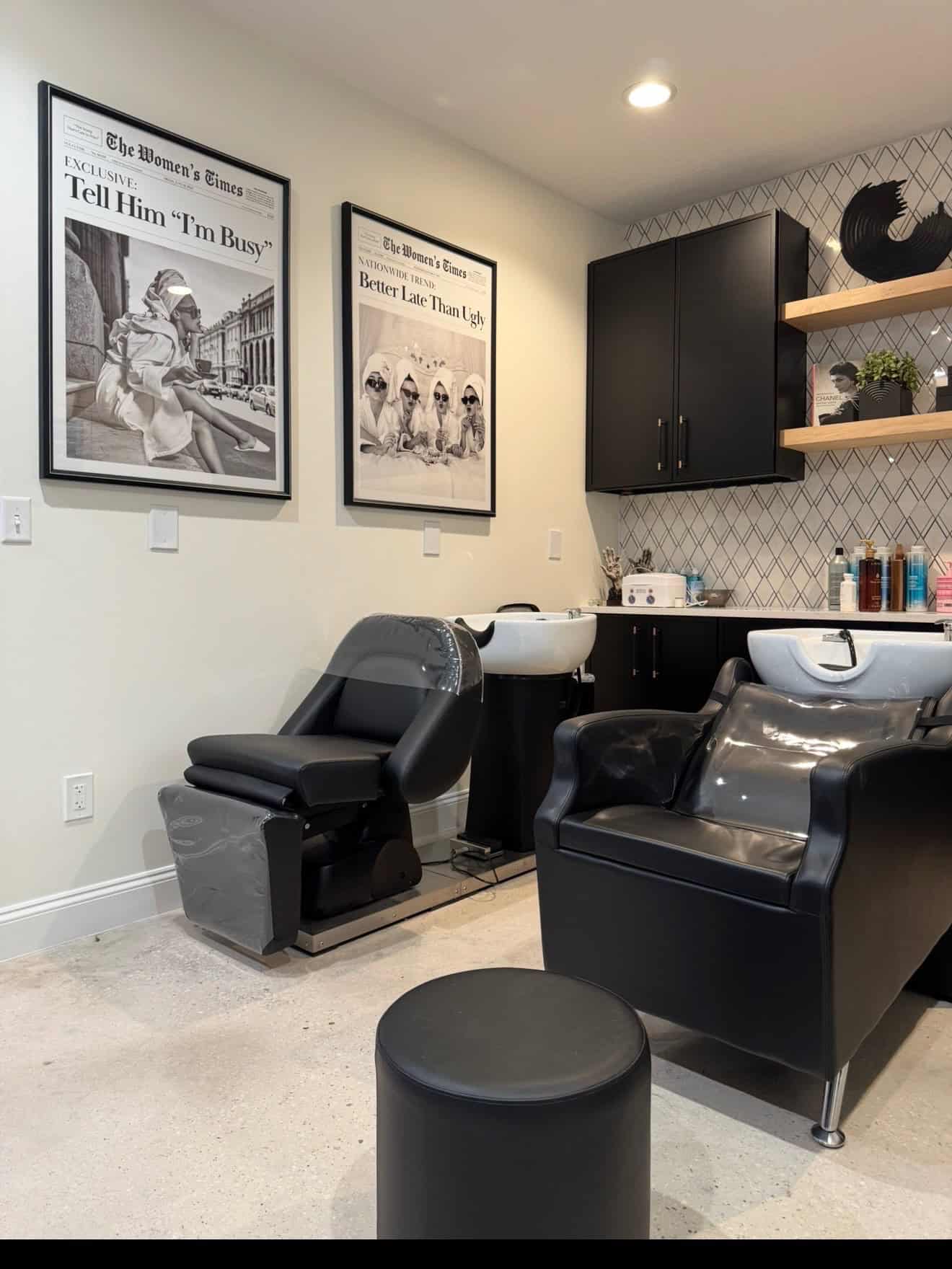 Modern hair salon wash stations with black chairs and stylish decor.