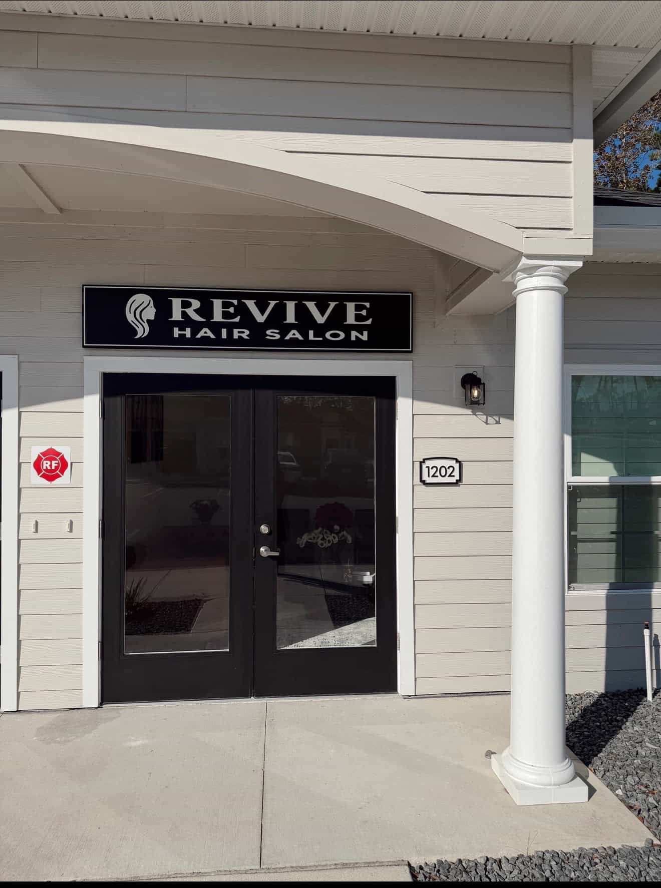 Exterior view of Revive Hair Salon with entrance, sign, and building details.