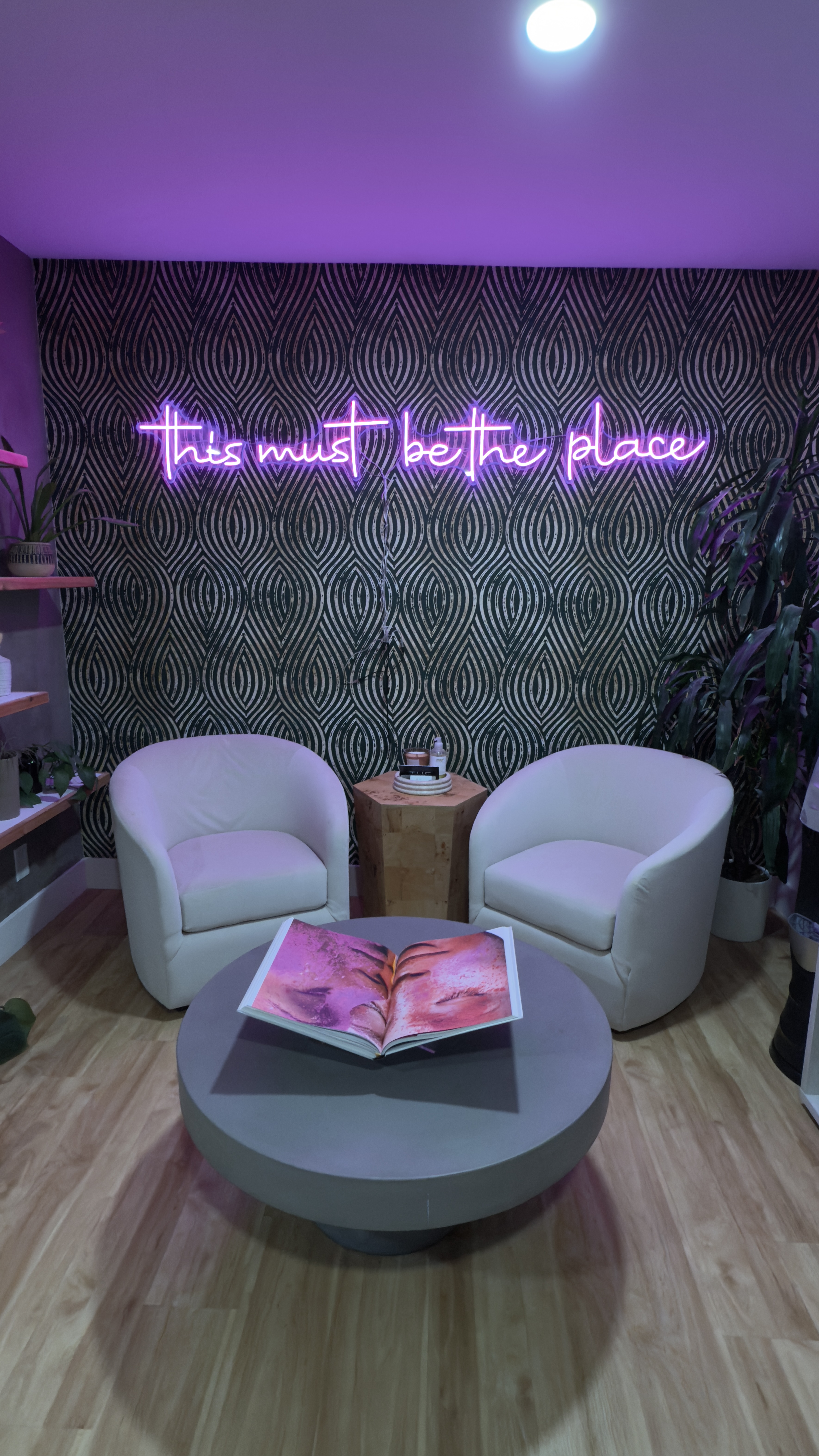 Cozy salon waiting area with modern decor, neon sign, and comfortable chairs for clients. Perfect fo.