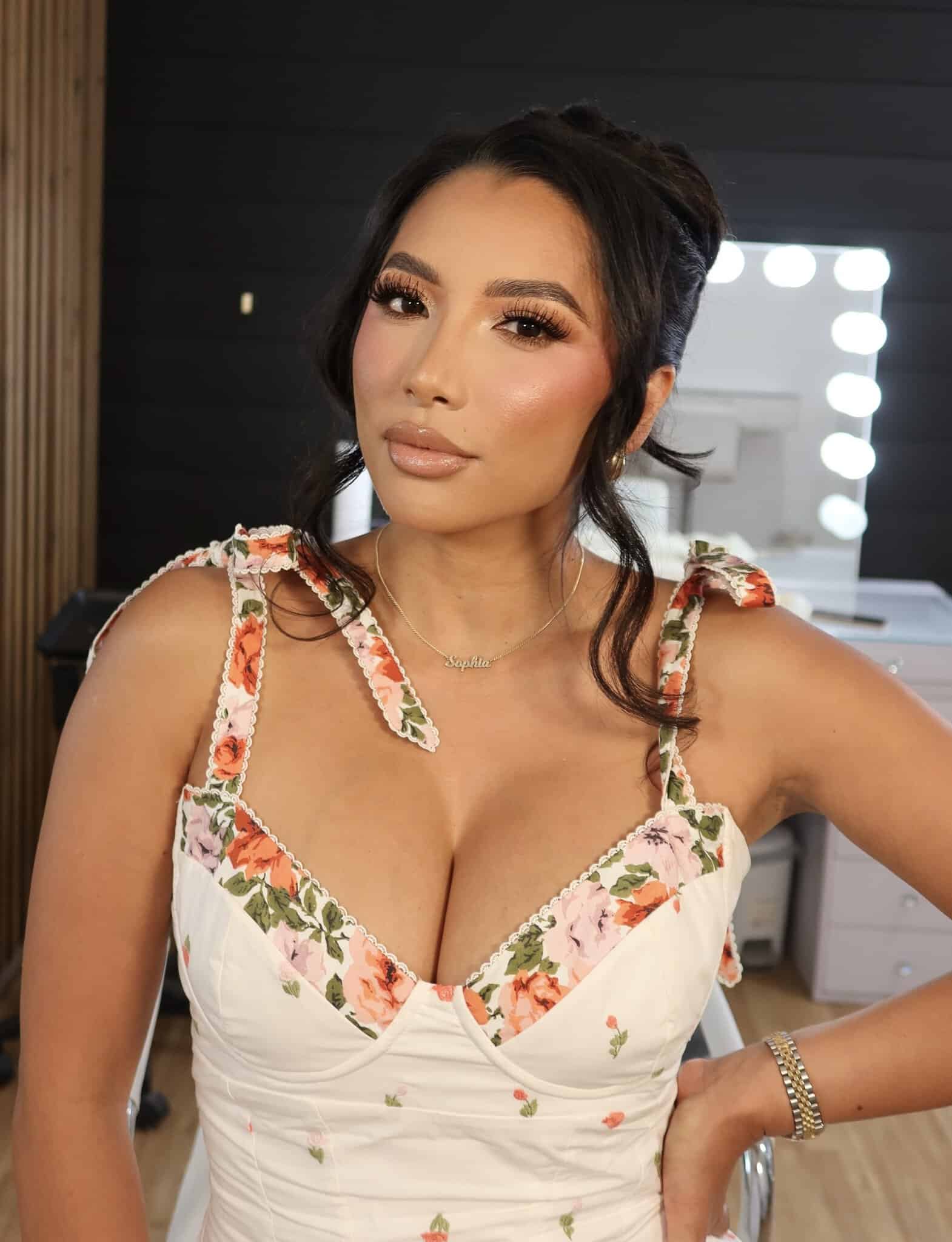 Elegant woman in floral dress with makeup and styled hair in salon.