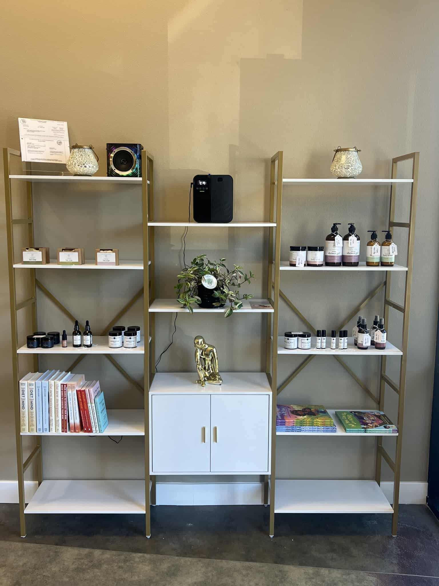 Bright salon shelving unit with beauty products, books, and decorative accents.