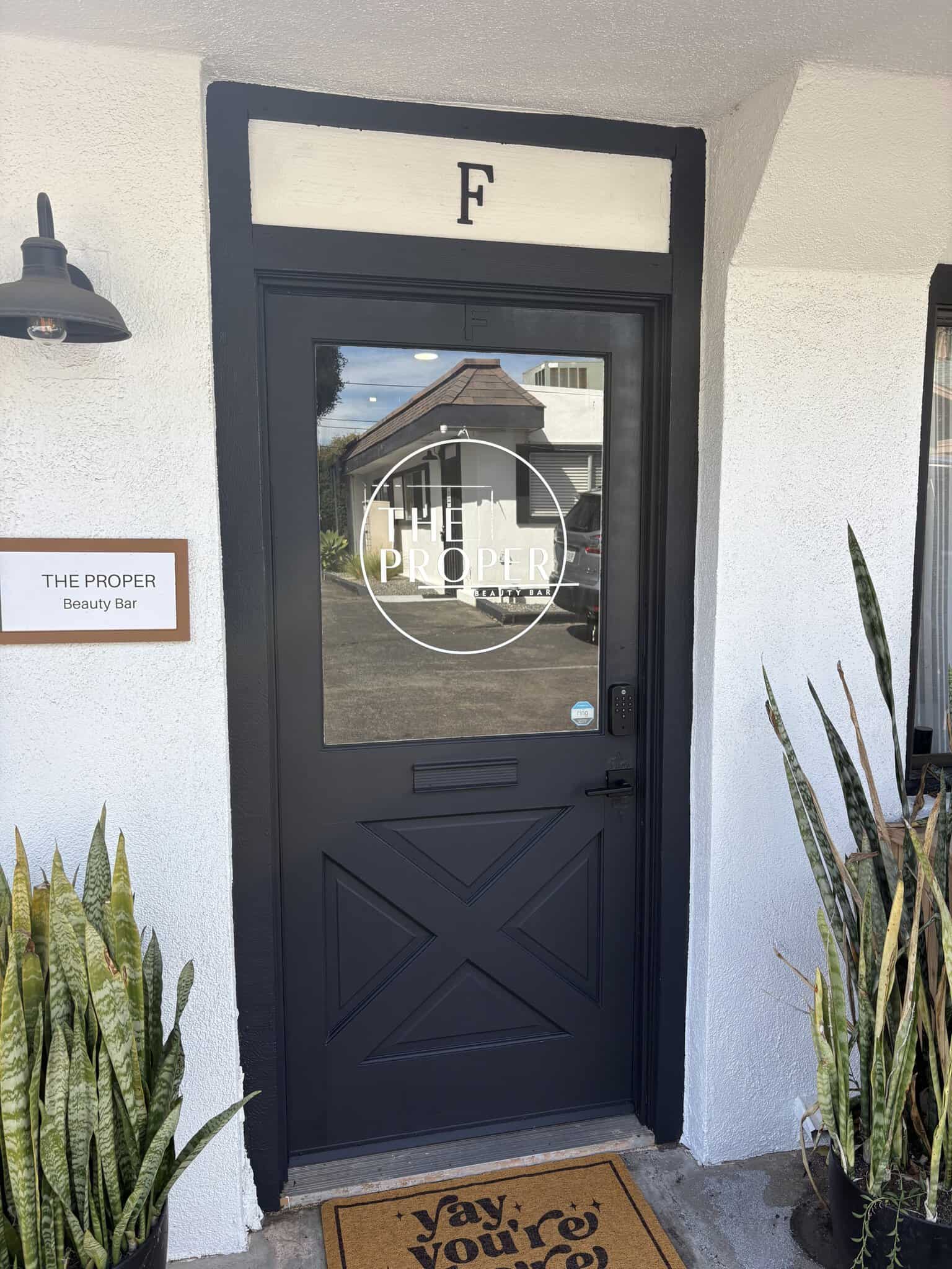 Entrance door to Salon Renter with a black frame and glass panel.