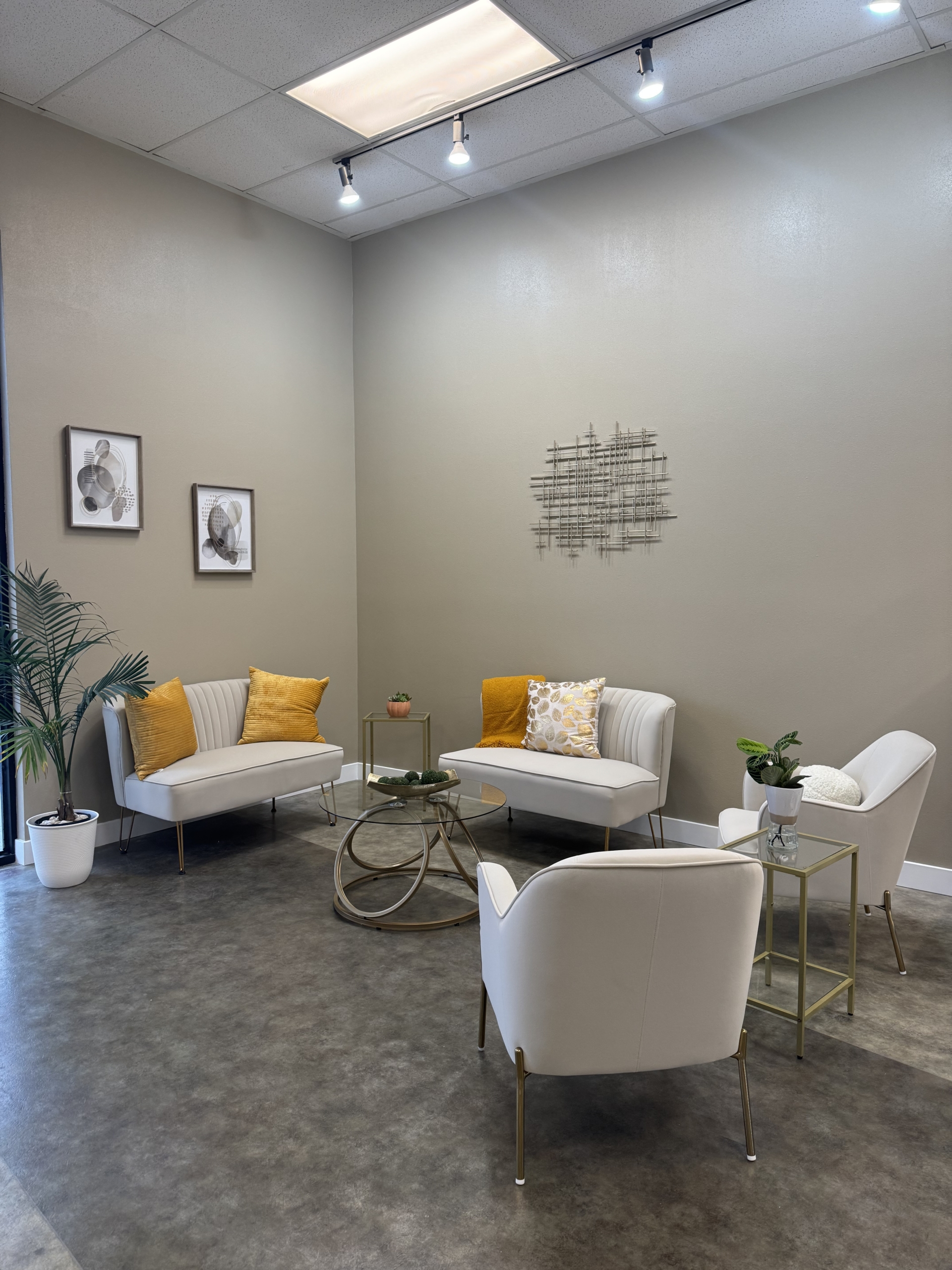 Comfortable salon lounge with stylish white and yellow seating, modern decor, and relaxing ambiance.
