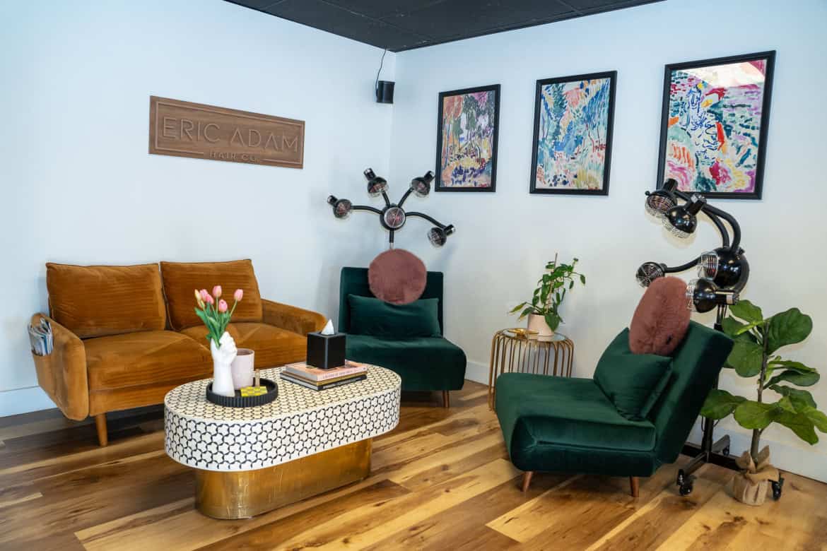 Comfortable salon lounge with stylish seating and vibrant artwork.