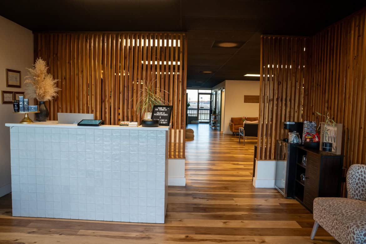 Stylish salon reception with wooden accents, cozy seating, and welcoming atmosphere for clients.