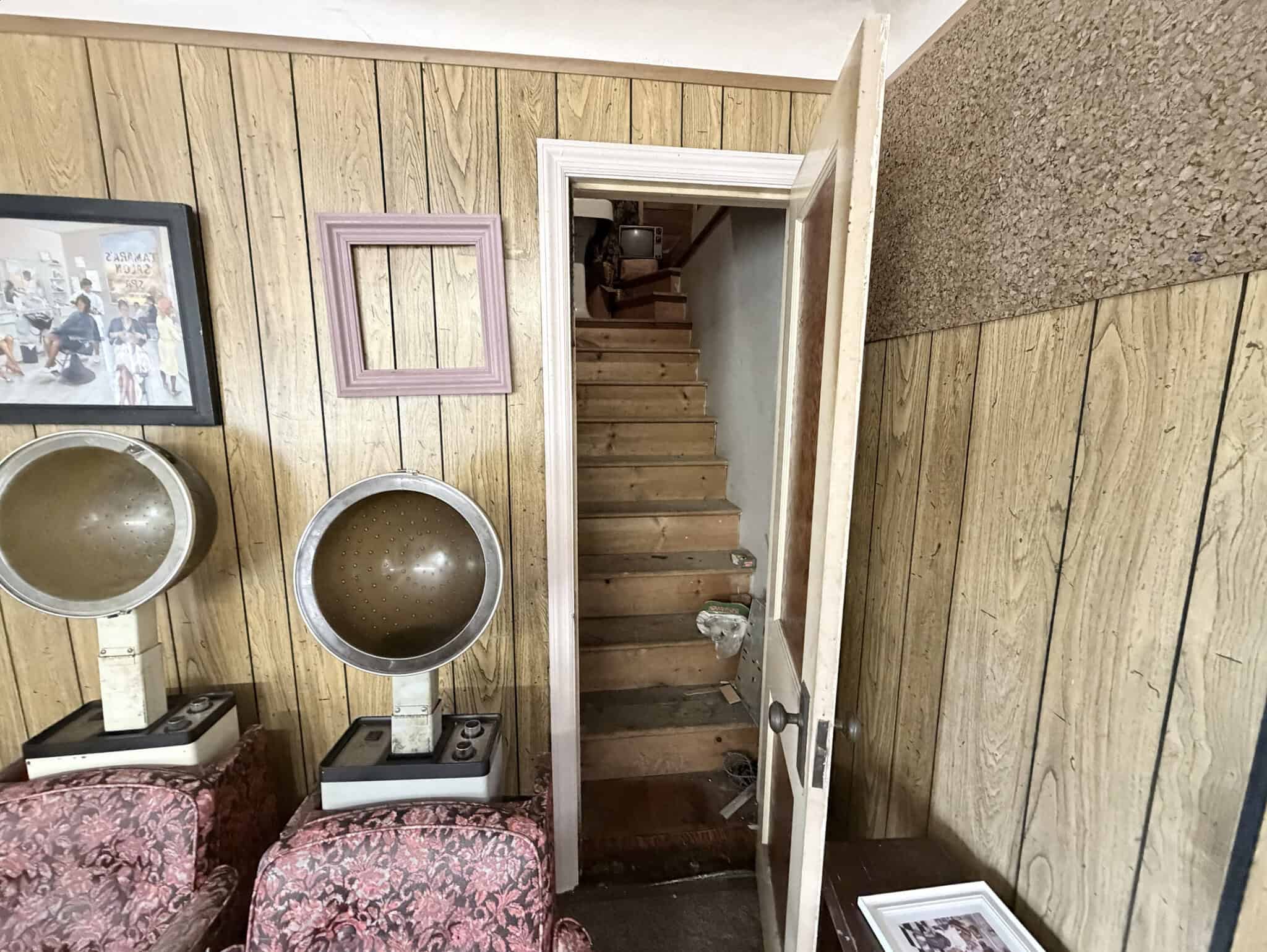 Hair salon equipment with vintage hairdryers and wooden wall decor.
