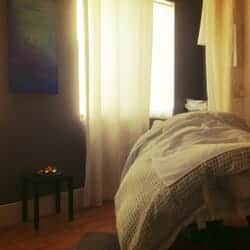 Cozy bedroom with natural sunlight, curtains, and a neatly made bed, ideal for salon professionals r.